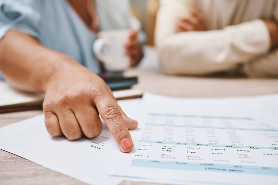 Finance, budget and couple hands for planning, paperwork and financial advisor review, analysis or advice. Accounting, banking person with taxes, payment quote or bills for mortgage or loan documents