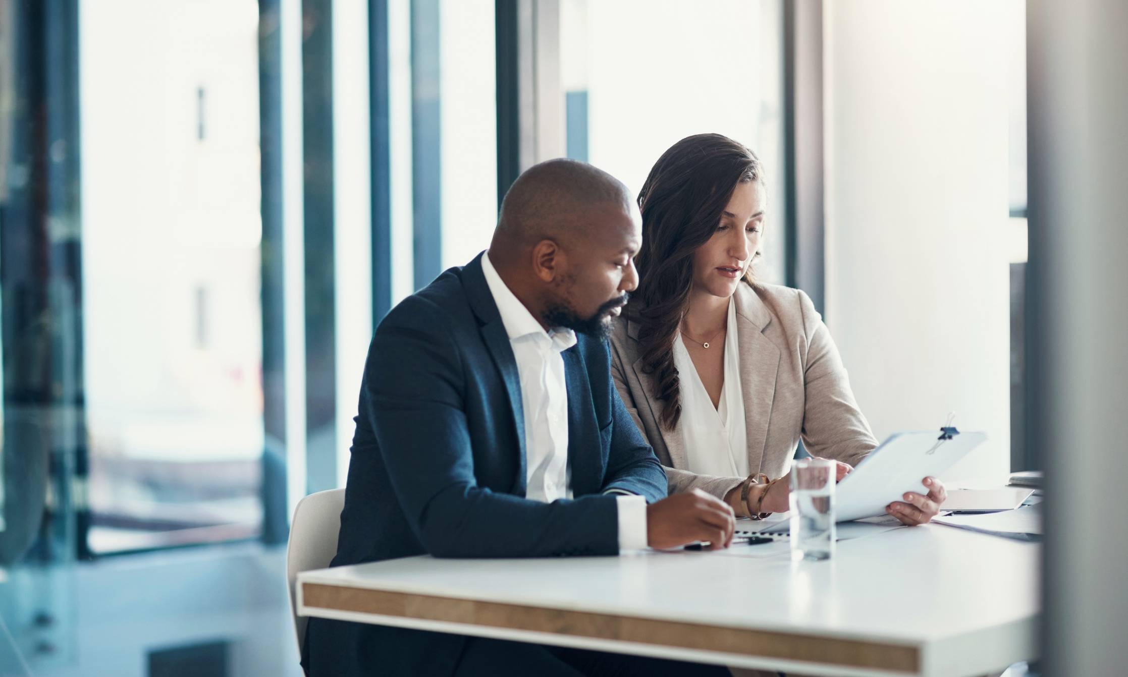 Office, woman and man with contract, consulting and financial advice for business plan or audit report. Accounting, finance and businessman with tax advisor checking paperwork for review or feedback.